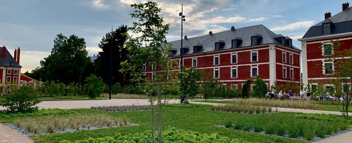 Vue de la caserne réhabilitée ainsi que des places de parking végétalisées